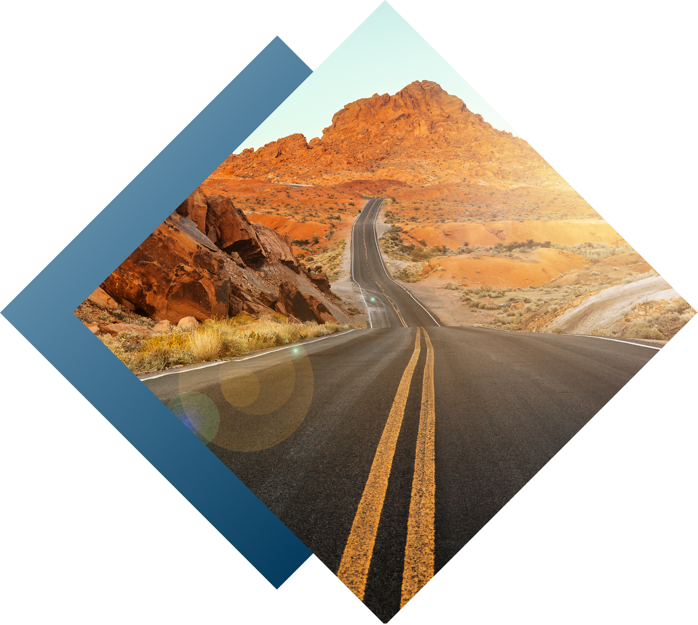 Desert road with mountains and sun flare.