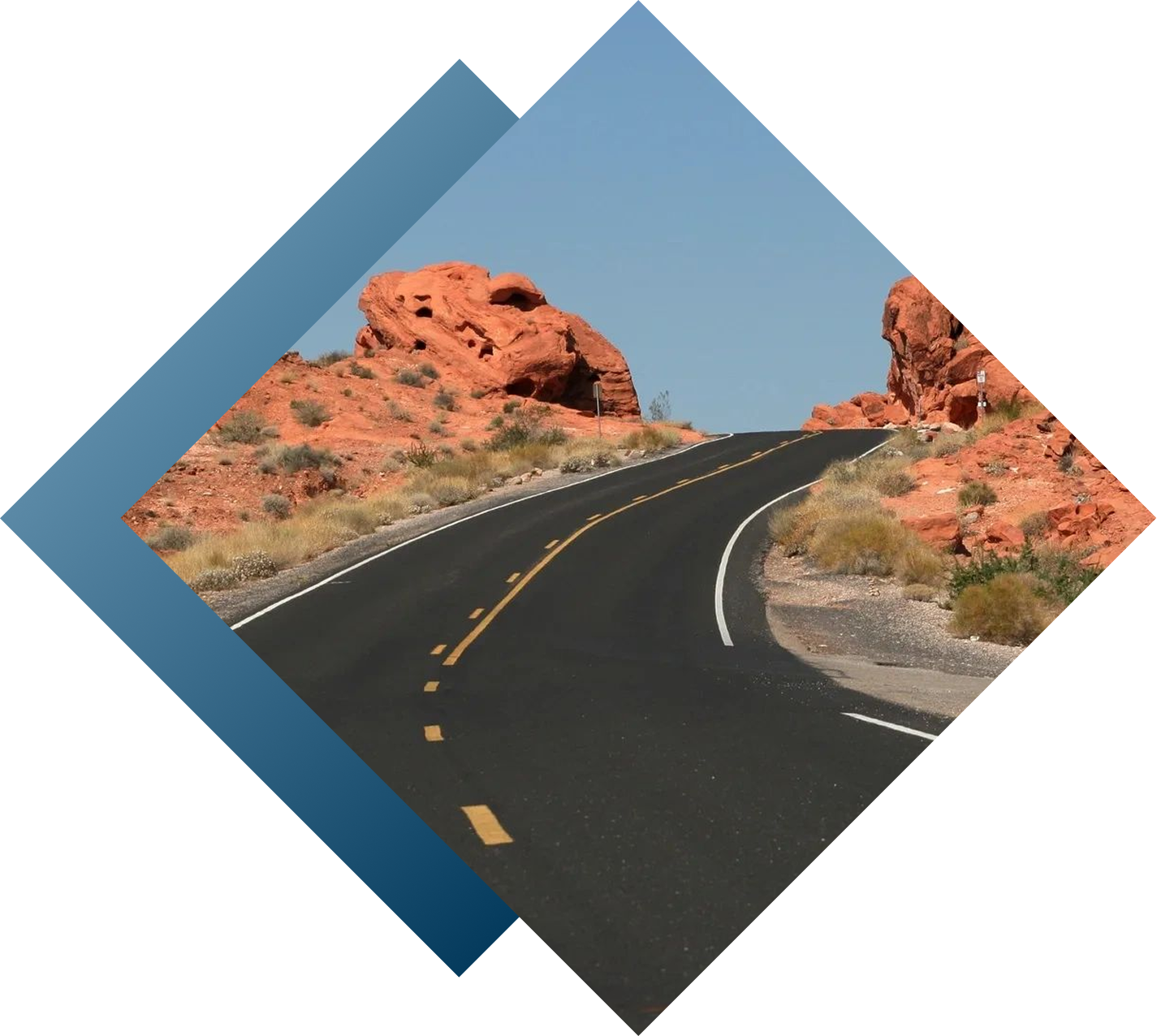 Desert road winding through red rock formations.