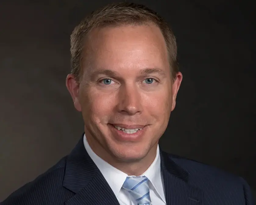 Smiling man in a suit and tie.